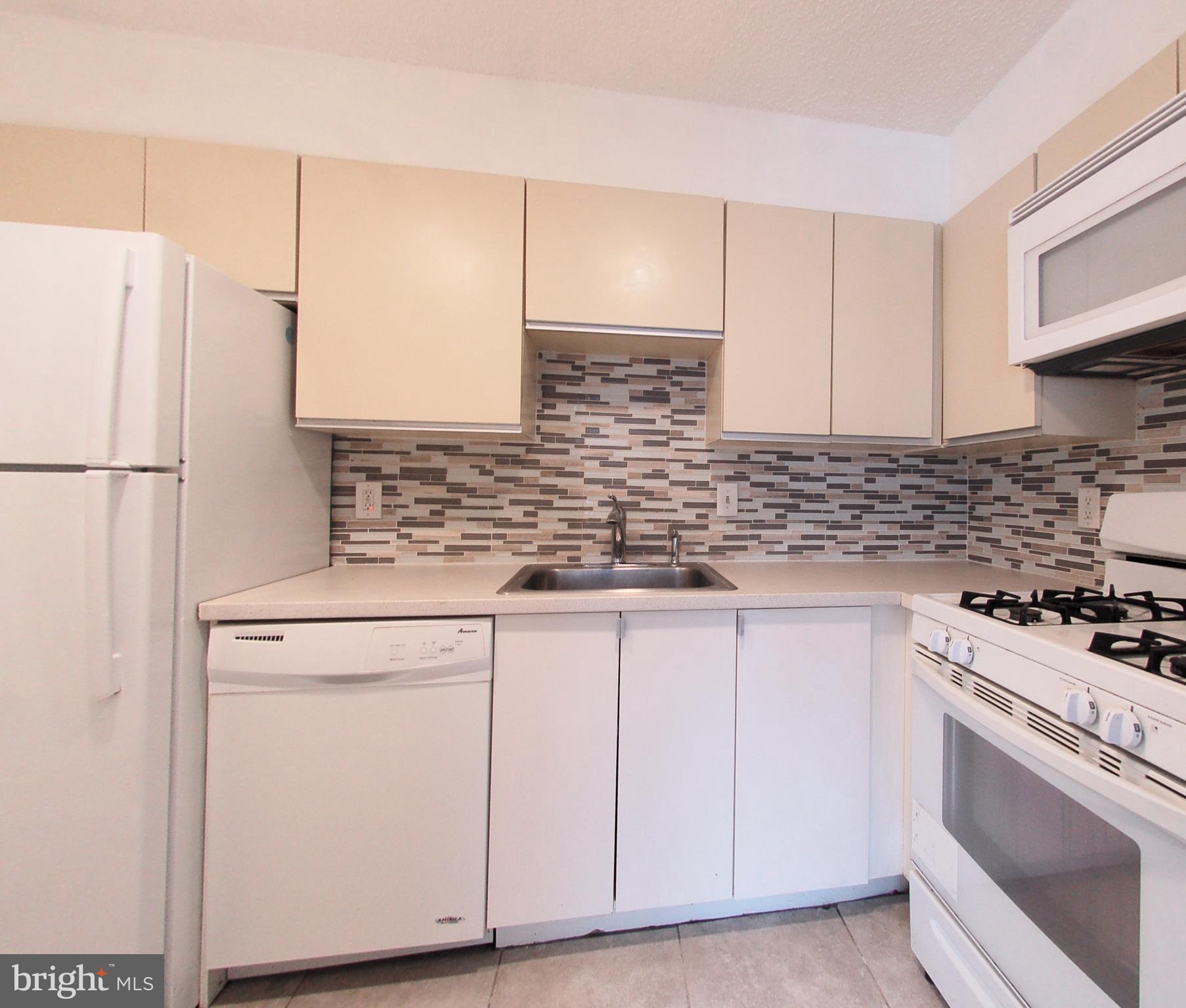 1245 13th Street Northwest, Unit 615 Washington, DC 20005 - Photo 2 of 18 a kitchen with granite countertop white cabinets and white appliances
