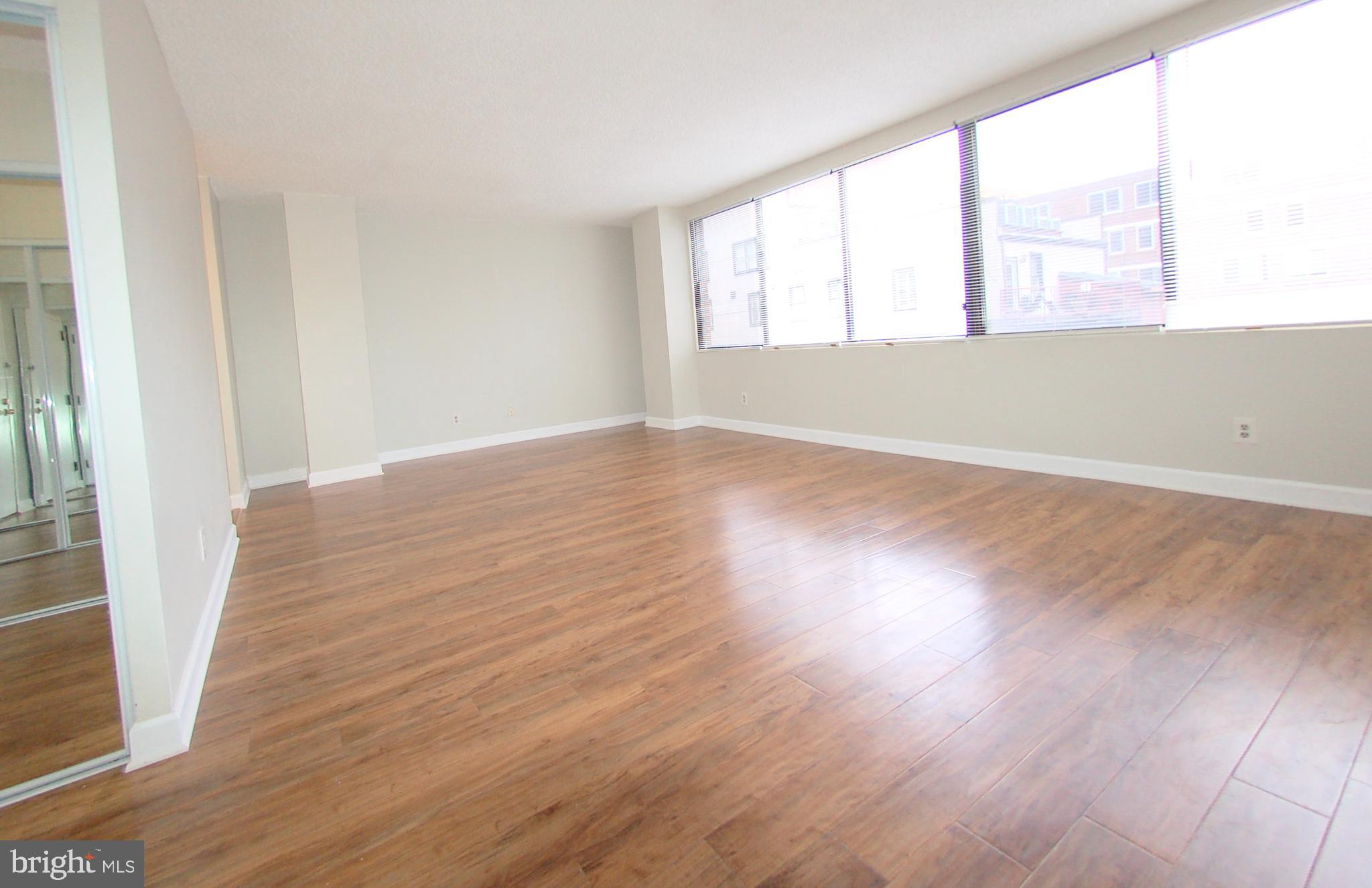 1245 13th Street Northwest, Unit 615 Washington, DC 20005 - Photo 5 of 18 an empty room with wooden floor and windows