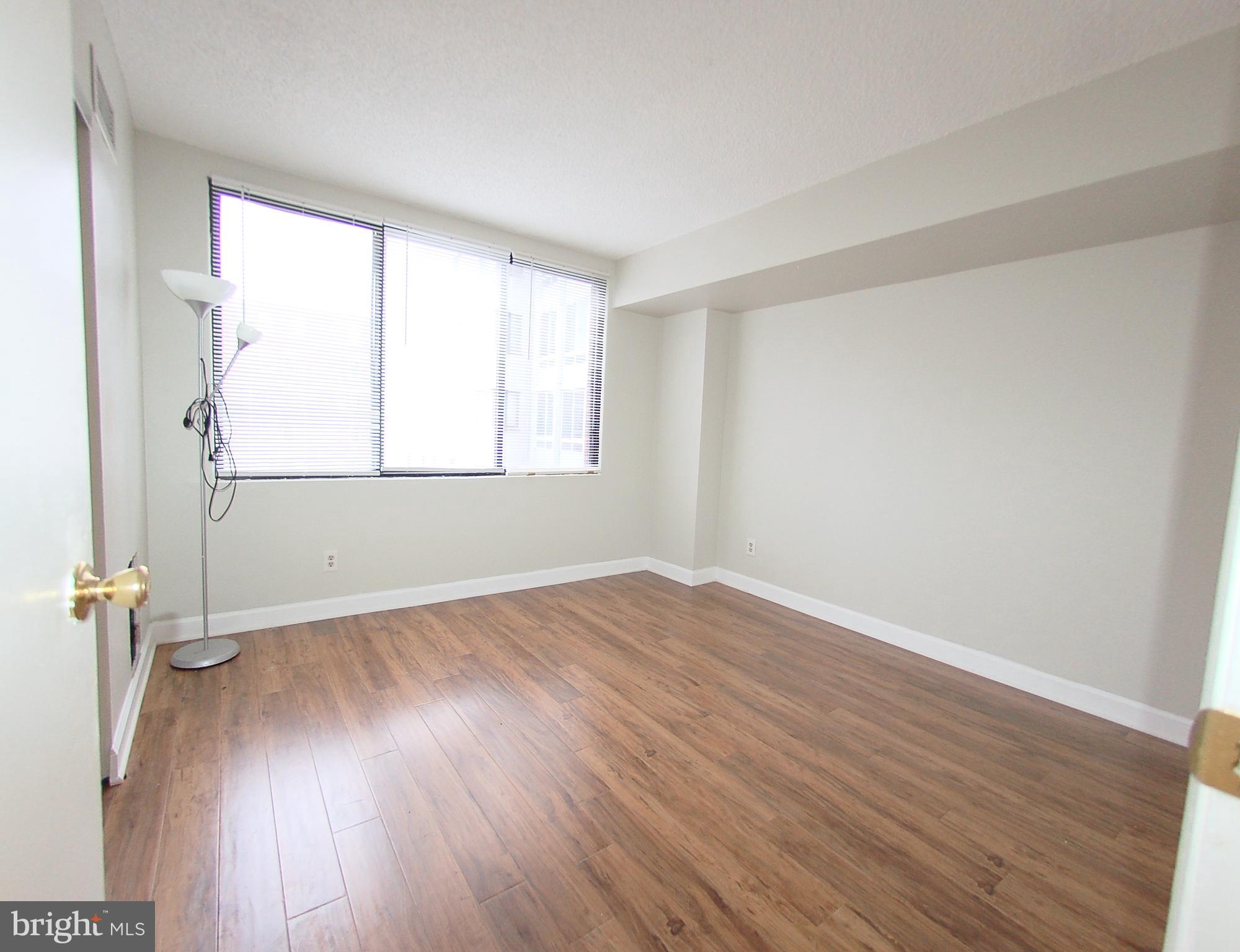 1245 13th Street Northwest, Unit 615 Washington, DC 20005 - Photo 9 of 18 an empty room with wooden floor and windows