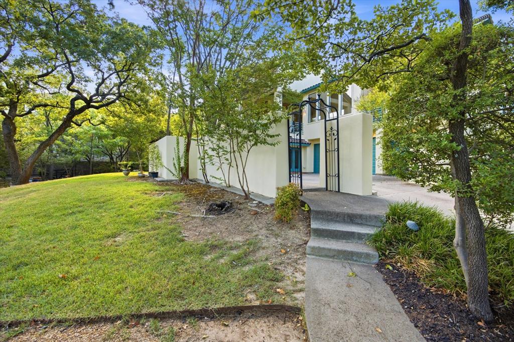 3606 Labrador Grapevine, TX 76051 - Photo 8 of 38 Stone steps and a concrete pathway leading to an ornate iron gate