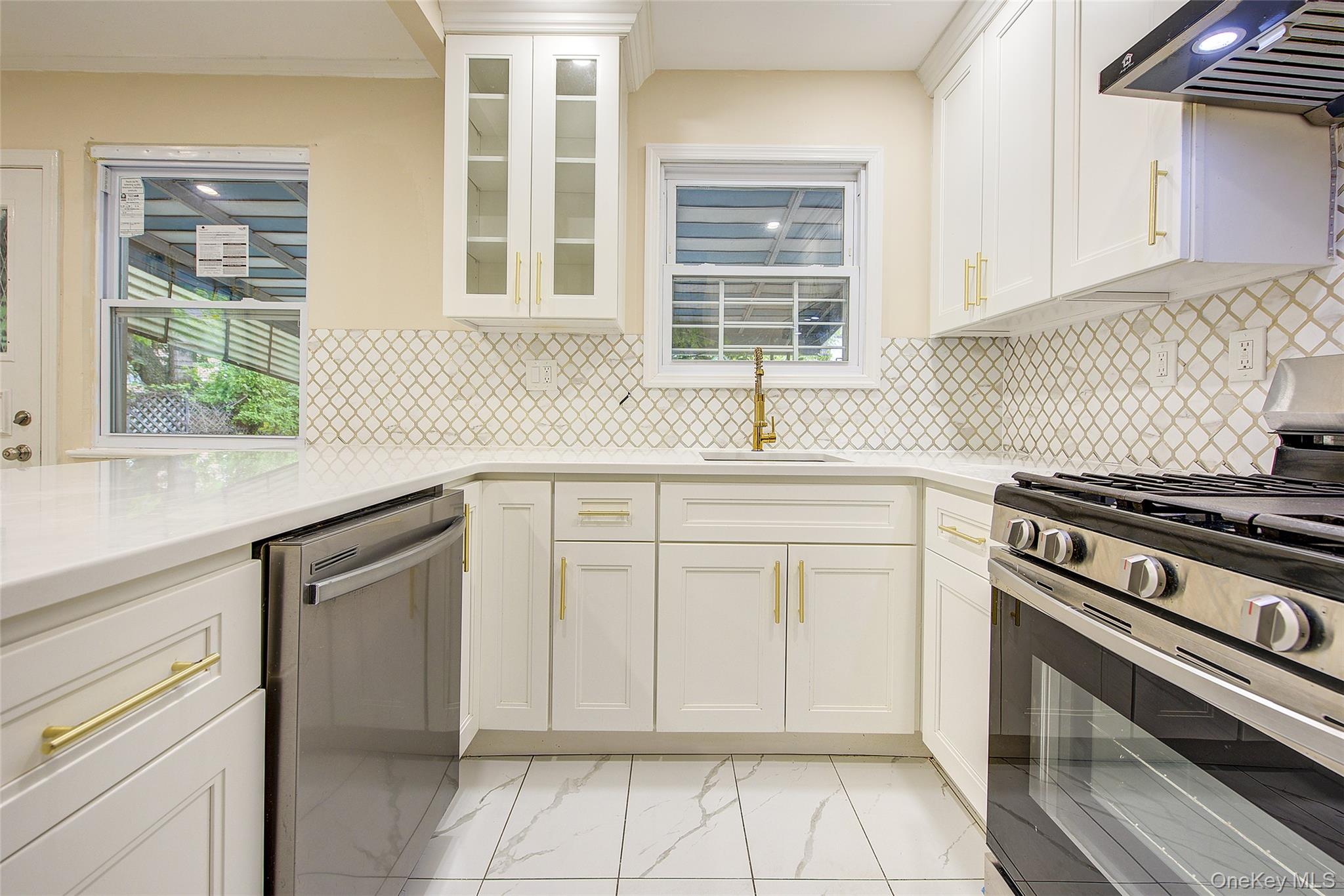 164-38 76th Road Queens, NY 11366 - Photo 10 of 44 a kitchen with white cabinets and appliances