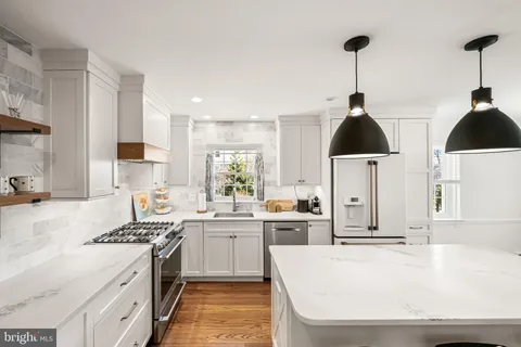 a kitchen with stainless steel appliances a sink a stove and a wooden floors