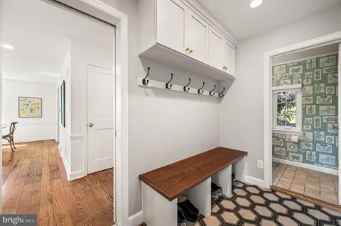 a view of a hallway with wooden floor and cabinet