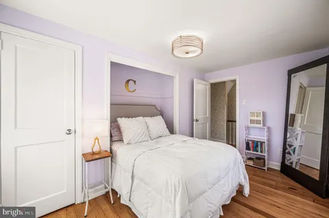 a bedroom with a bed and a flat tv screen on dresser