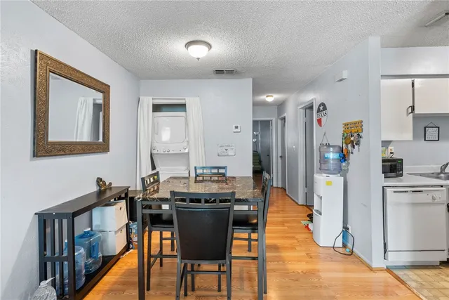 a dining hall with stainless steel appliances kitchen island granite countertop a dining table and chairs