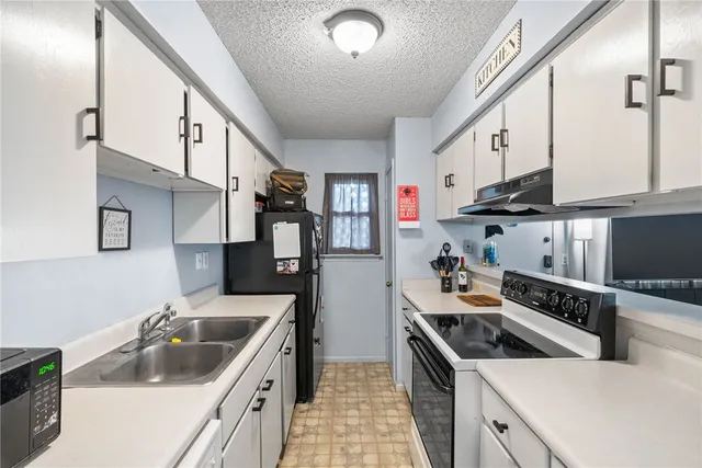 a kitchen with stainless steel appliances a sink a stove and a refrigerator