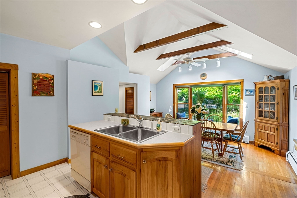 21 Preston Beach Road Marblehead, MA 01945 - Photo 15 of 34 a kitchen with a stove a refrigerator a dining table and chairs with wooden floor