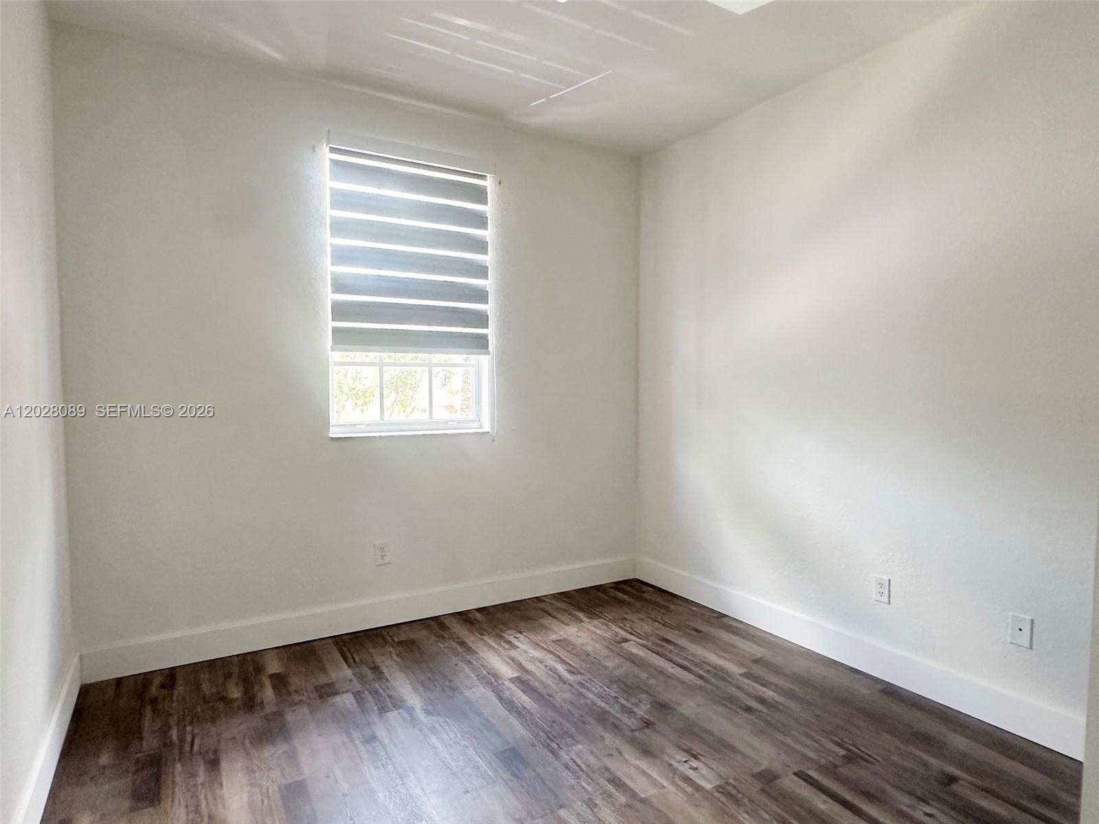 662 Northeast 21st Terrace Homestead, FL 33033 - Photo 20 of 34 an empty room with wooden floor and windows