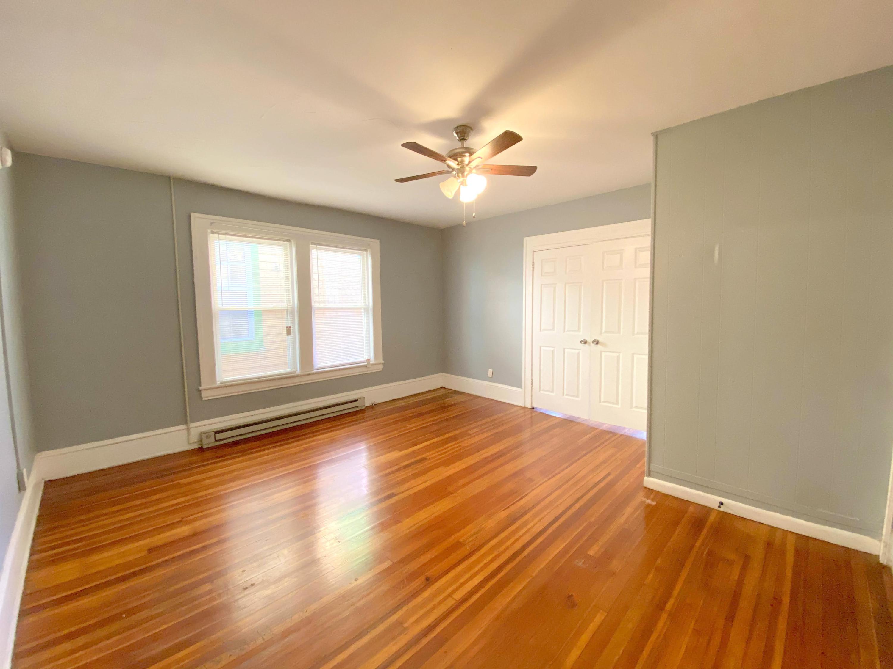 1306 Patterson Avenue Southwest, Unit 3 Roanoke, VA 24016 - Photo 11 of 28 an empty room with wooden floor ceiling fan and windows