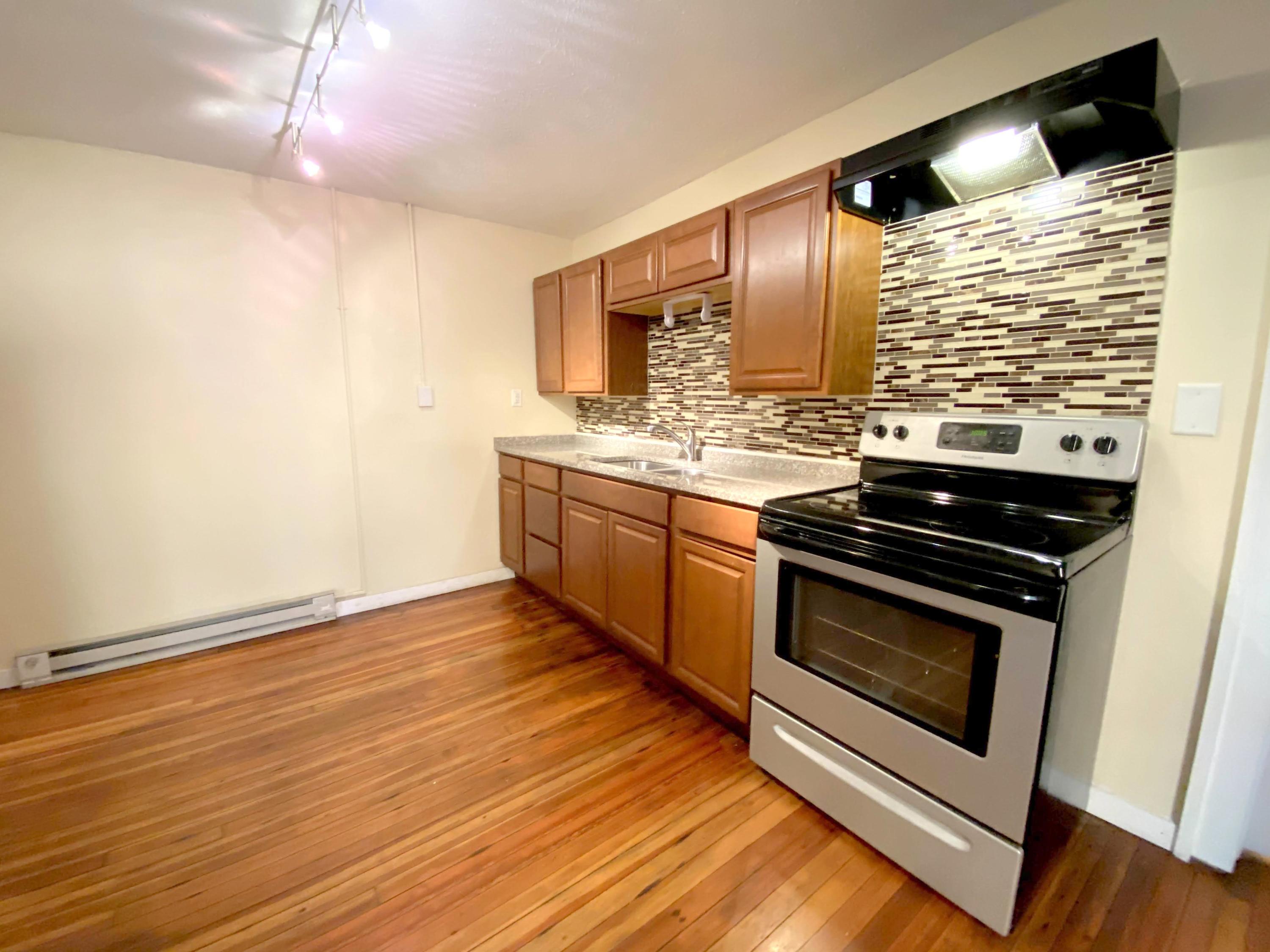 1306 Patterson Avenue Southwest, Unit 3 Roanoke, VA 24016 - Photo 15 of 28 a kitchen with stainless steel appliances wooden floor sink and wooden cabinets