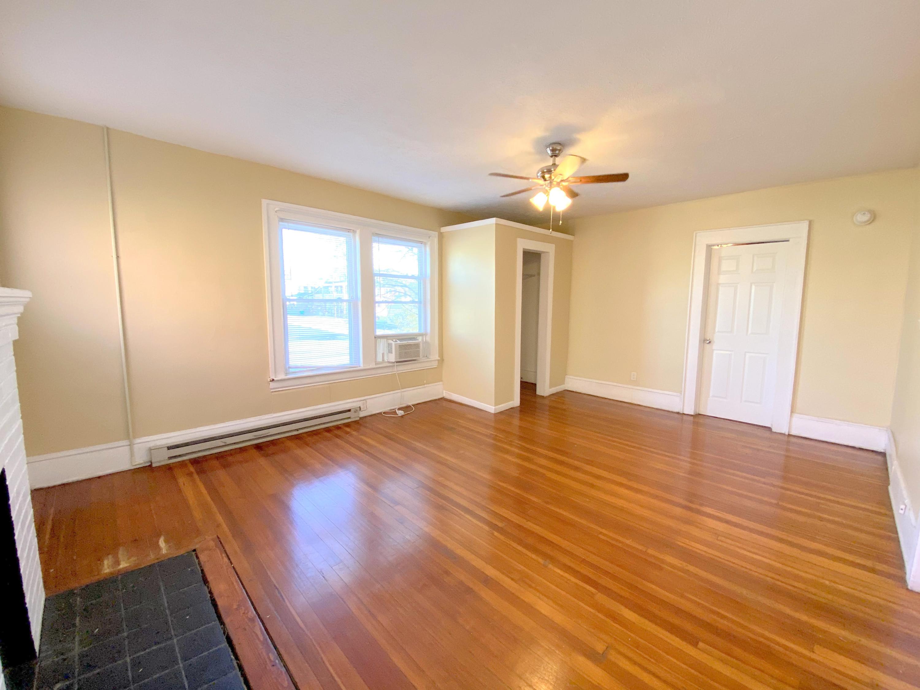 1306 Patterson Avenue Southwest, Unit 3 Roanoke, VA 24016 - Photo 21 of 28 an empty room with wooden floor chandelier fan and windows