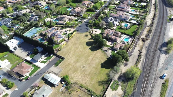 an aerial view of a residential houses with yard