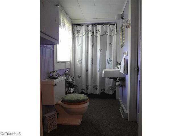 7701 Broad Street Rural Hall, NC 27045 - Photo 13 of 16 Exterior Front. Half bath. Behind curtain is storage but would make a great walk in shower or tub.