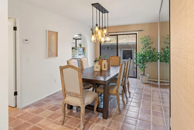 a dining room with furniture a chandelier and wooden floor