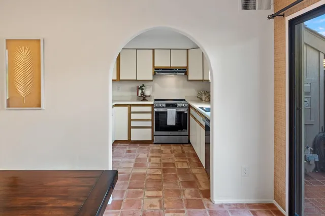 a kitchen with stainless steel appliances white cabinets and a stove top oven