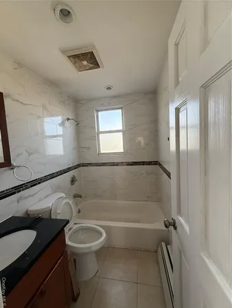 a bathroom with a granite countertop bathtub sink vanity mirror and toilet