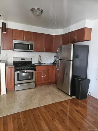 a kitchen with stainless steel appliances a stove a refrigerator and a microwave