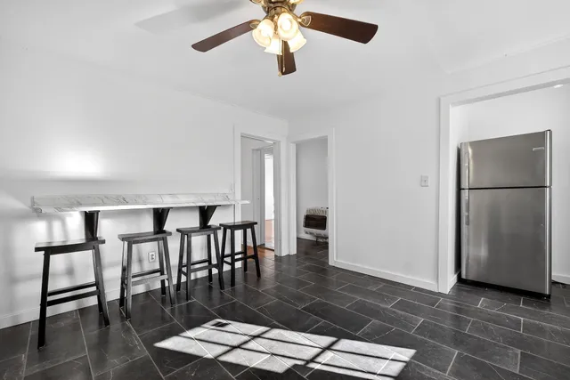 a living room with stainless steel appliances furniture a rug and a window