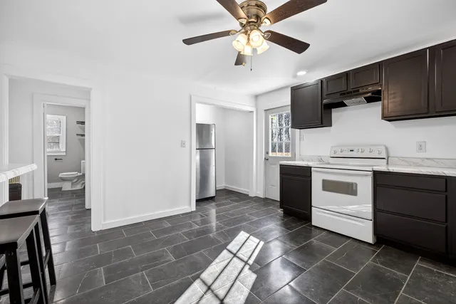 a kitchen with stainless steel appliances a stove a microwave and white cabinets