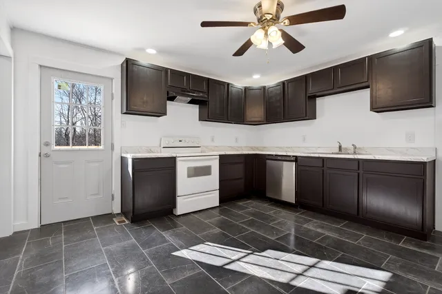 a kitchen with stainless steel appliances kitchen island granite countertop a sink and a stove
