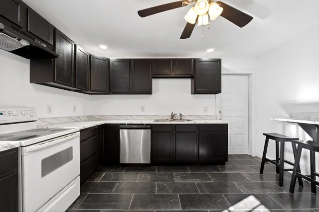 a kitchen with stainless steel appliances granite countertop a sink and a stove