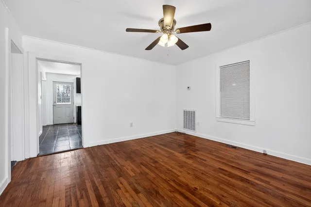 a view of empty room with wooden floor
