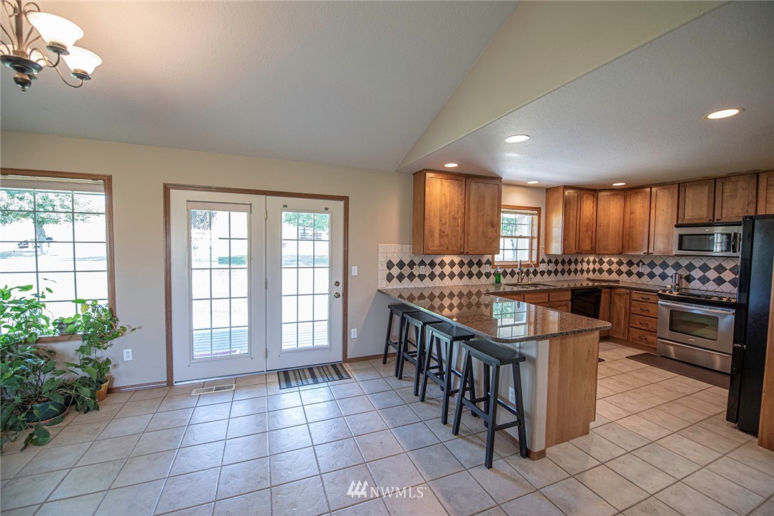 7483 Frog Hollow Road Touchet, WA 99360 - Photo 8 of 25 a kitchen with stainless steel appliances granite countertop a stove a sink and a refrigerator