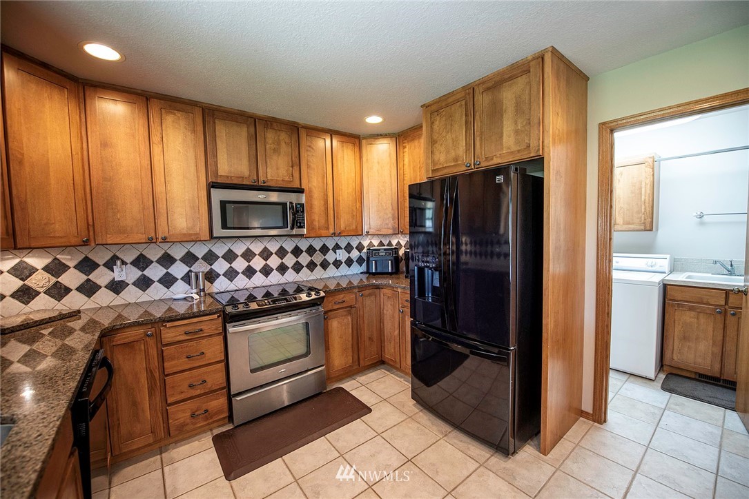 7483 Frog Hollow Road Touchet, WA 99360 - Photo 9 of 25 a kitchen with granite countertop a refrigerator and a sink