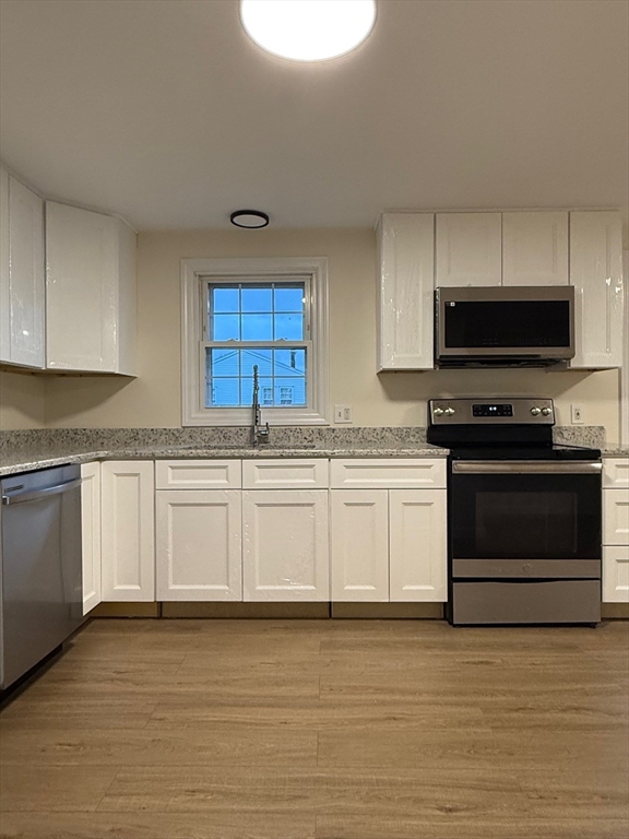 17 Horace Street, Unit 2 Boston, MA 02128 - Photo 2 of 14 a kitchen with granite countertop a stove a sink and a microwave