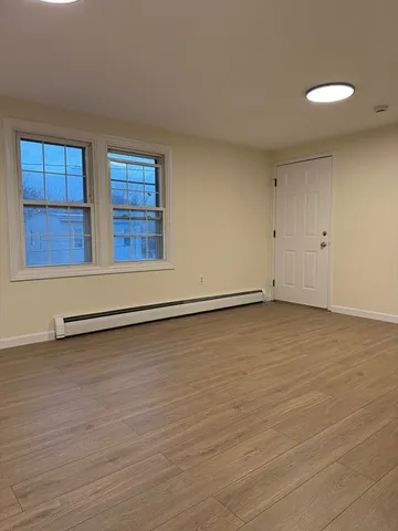 a view of a room with wooden floor and window