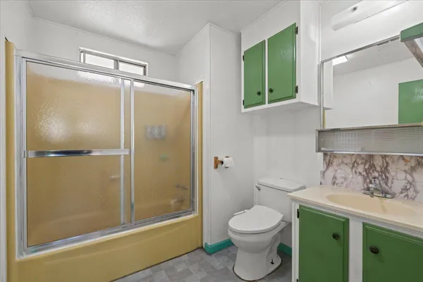 a bathroom with a granite countertop sink toilet and shower