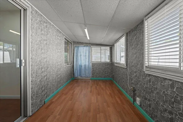a view of hallway with window and wooden floor
