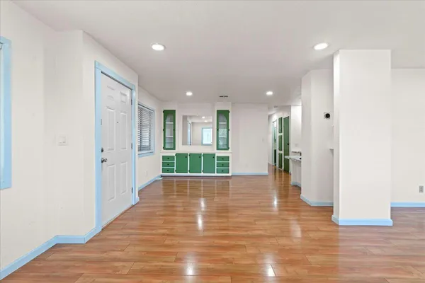 a view of a hallway with wooden floor and a living room
