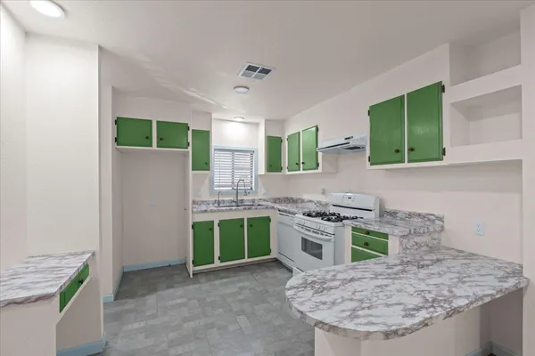 a kitchen with stainless steel appliances granite countertop a sink stove and refrigerator
