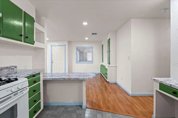 a kitchen with kitchen island granite countertop a stove and a sink
