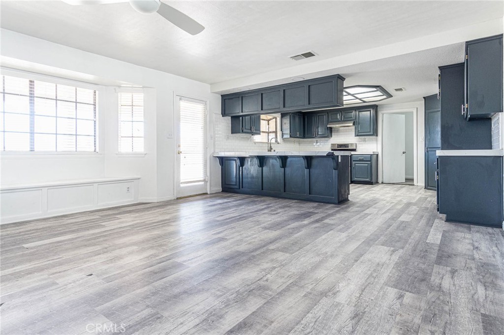 13114 Choco Road Apple Valley, CA 92308 - Photo 11 of 75 a large kitchen with stainless steel appliances wooden floors and wooden cabinets