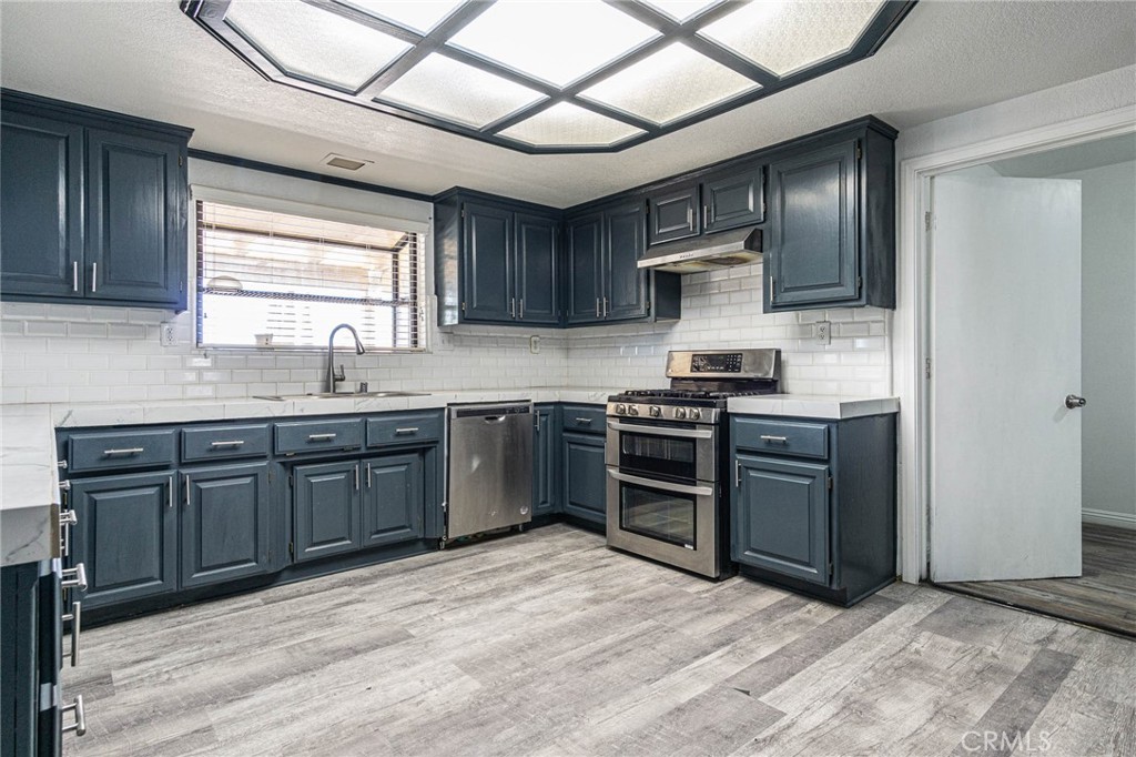 13114 Choco Road Apple Valley, CA 92308 - Photo 13 of 75 a kitchen with stainless steel appliances granite countertop a stove sink and cabinets