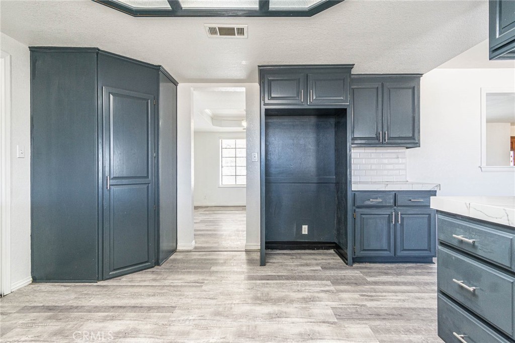 13114 Choco Road Apple Valley, CA 92308 - Photo 14 of 75 a kitchen with granite countertop wooden cabinets and entryway