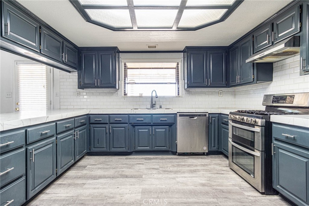 13114 Choco Road Apple Valley, CA 92308 - Photo 17 of 75 a kitchen with stainless steel appliances granite countertop a sink and wooden cabinets
