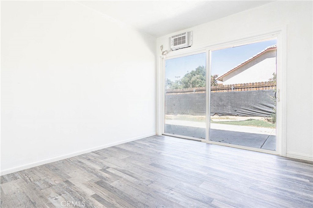 13114 Choco Road Apple Valley, CA 92308 - Photo 19 of 75 a view of an empty room with wooden floor and a window