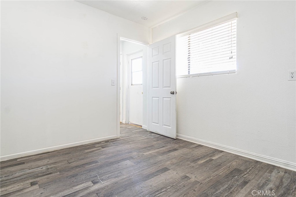 13114 Choco Road Apple Valley, CA 92308 - Photo 30 of 75 an empty room with wooden floor and windows