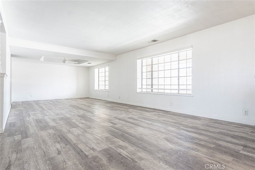 13114 Choco Road Apple Valley, CA 92308 - Photo 4 of 75 an empty room with wooden floor and windows