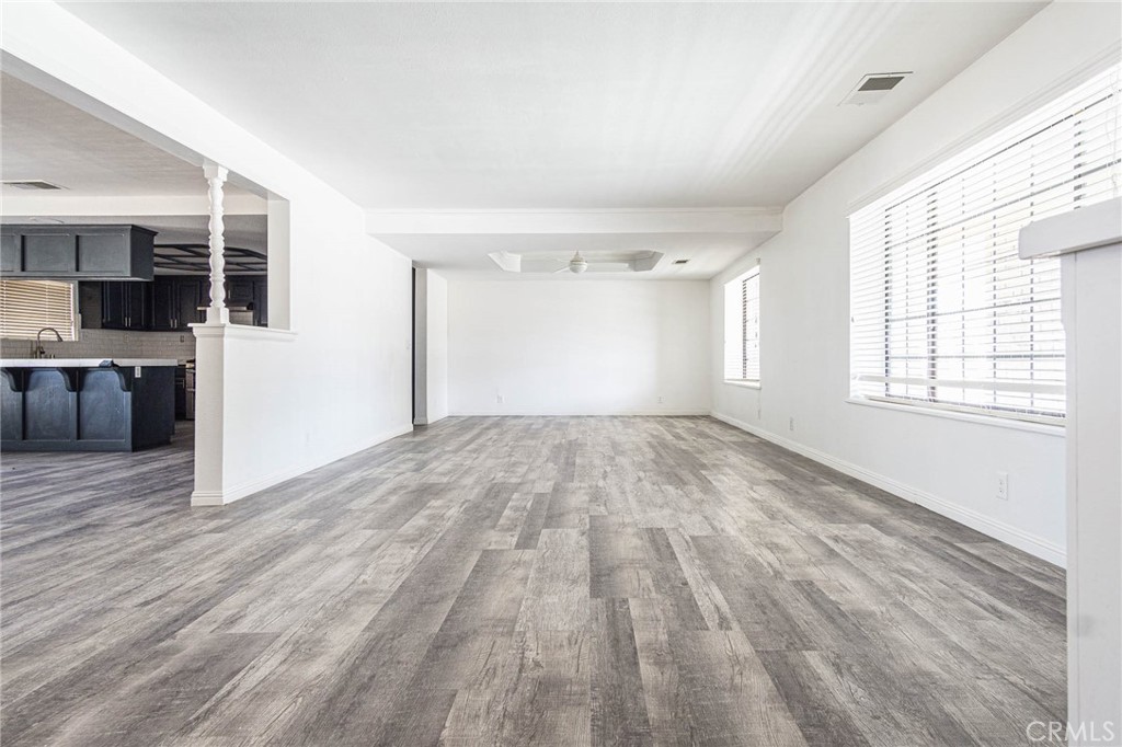 13114 Choco Road Apple Valley, CA 92308 - Photo 6 of 75 an empty room with wooden floor and windows