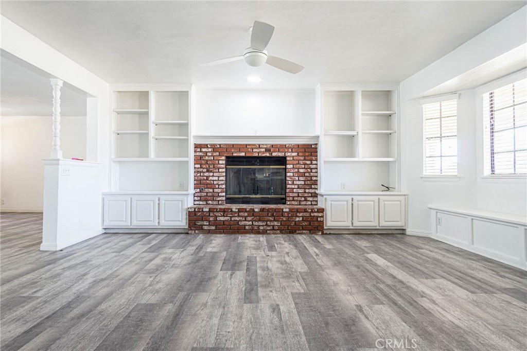 13114 Choco Road Apple Valley, CA 92308 - Photo 9 of 75 an empty room with wooden floor fireplace and windows