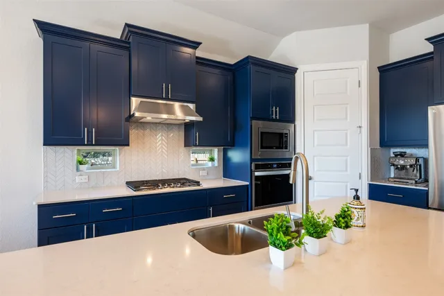 a kitchen with stainless steel appliances granite countertop wooden cabinets and a sink