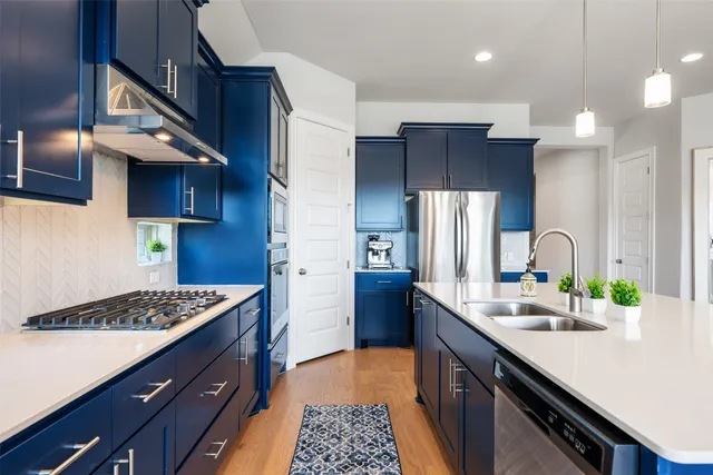 a kitchen with a sink stainless steel appliances a counter space and cabinets