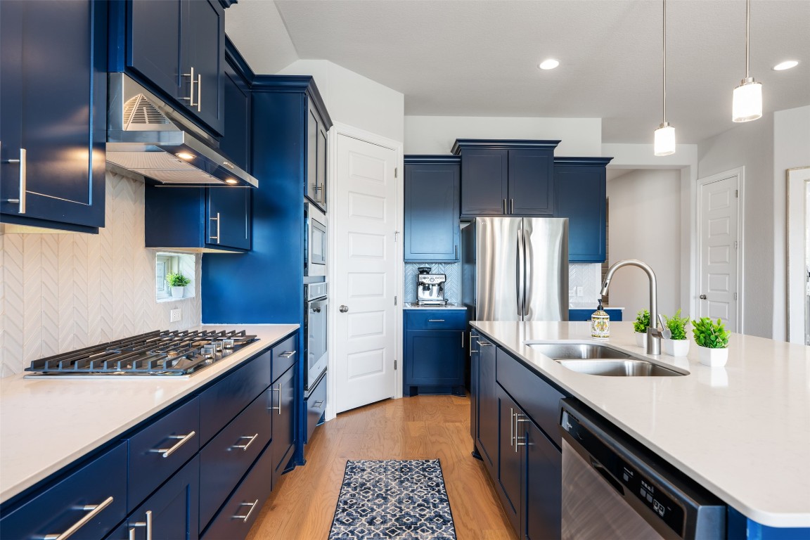 686 Treadwell Lane Kyle, TX 78640 - Photo 14 of 40 a kitchen with a sink stainless steel appliances a counter space and cabinets