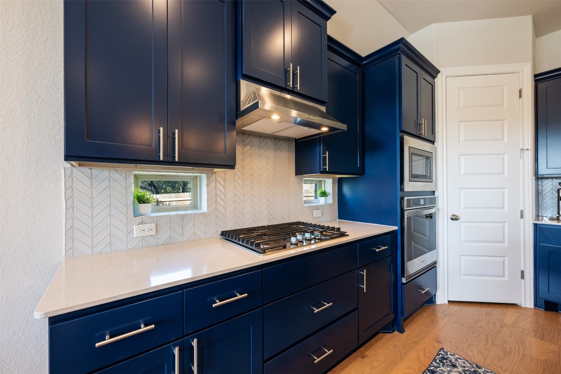 686 Treadwell Lane Kyle, TX 78640 - Photo 15 of 40 a kitchen with stainless steel appliances granite countertop a stove a sink and a microwave
