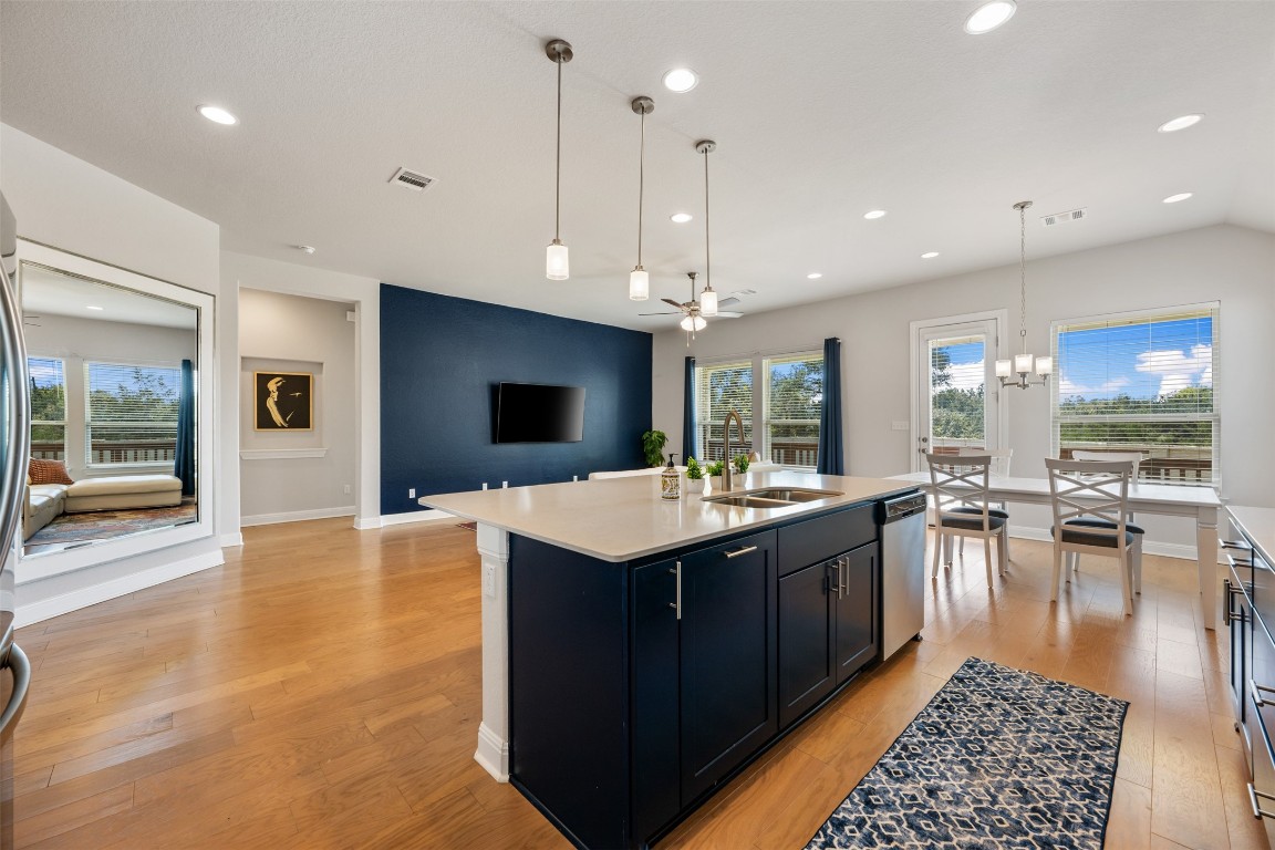 686 Treadwell Lane Kyle, TX 78640 - Photo 18 of 40 a large kitchen with kitchen island a sink counter space and living room view