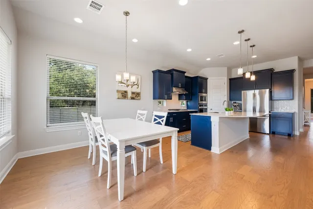 a kitchen with kitchen island a dining table and chairs